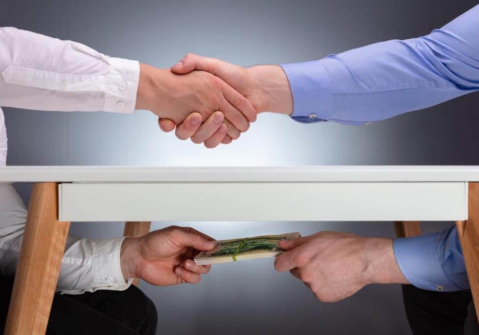 Businessmen Shaking Hands After The Business Deal Receiving A Bribe Money Under The Table